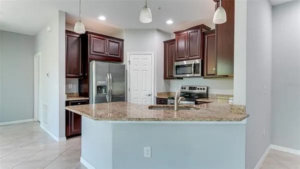 a kitchen with stainless steel appliances granite countertop a sink refrigerator and cabinets
