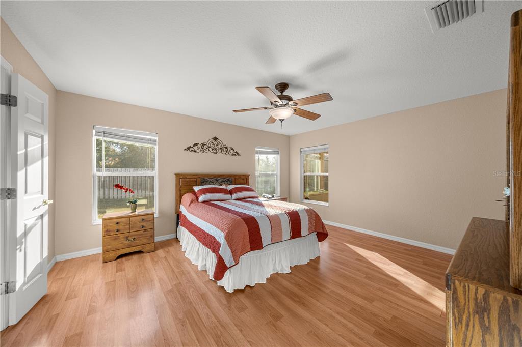 9175 Southeast 118th Loop Summerfield, FL 34491 - Photo 17 of 28 a bedroom with a bed and wooden floor
