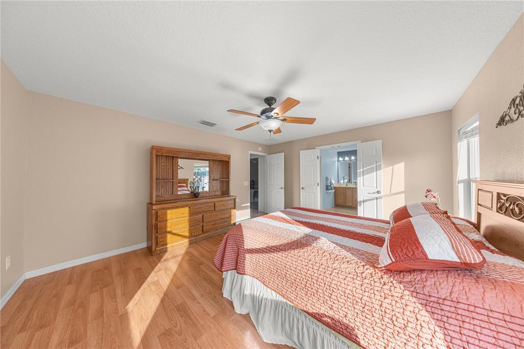 9175 Southeast 118th Loop Summerfield, FL 34491 - Photo 18 of 28 a bedroom with a bed and wooden floor