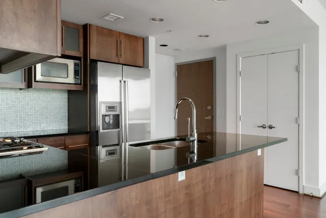 a kitchen with stainless steel appliances granite countertop a refrigerator and a sink