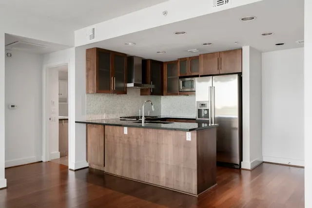 a kitchen with stainless steel appliances granite countertop a refrigerator a sink a stove and cabinets