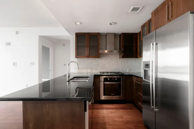 a kitchen with stainless steel appliances granite countertop a refrigerator and a stove