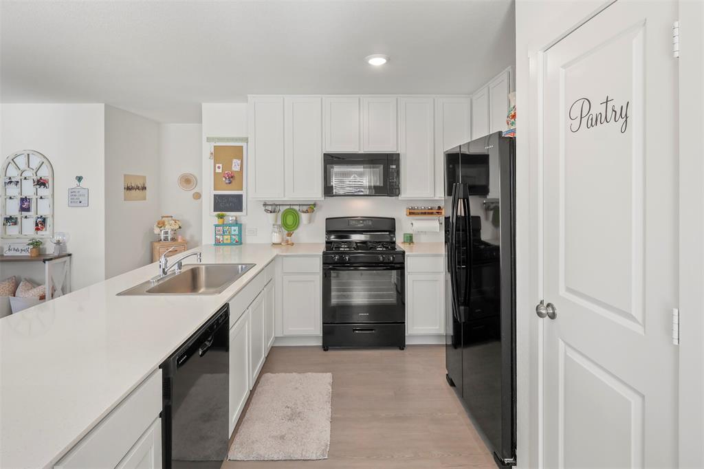 7229 Adderly Road Pilot Point, TX 76258 - Photo 14 of 34 a kitchen with a refrigerator and a sink