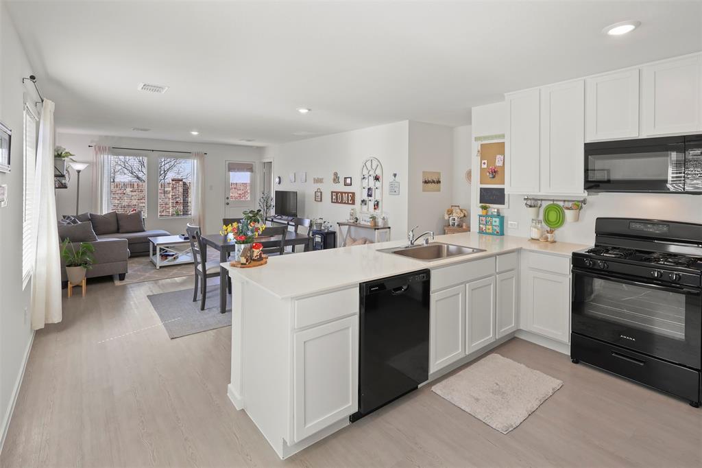 7229 Adderly Road Pilot Point, TX 76258 - Photo 15 of 34 a kitchen with a sink stove and cabinets