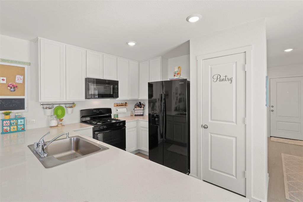 7229 Adderly Road Pilot Point, TX 76258 - Photo 16 of 34 a kitchen with a refrigerator stove and a sink