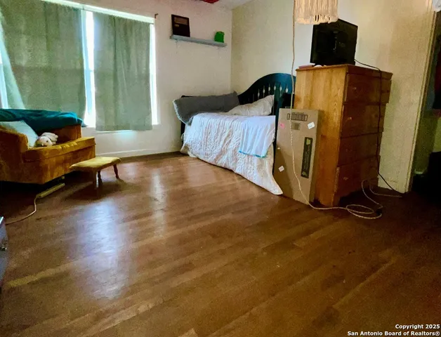 a bedroom with a bed and wooden floor
