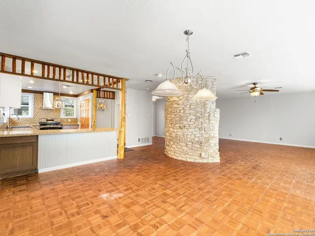 a view of a living room and chandelier fan