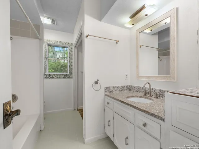 a bathroom with a granite countertop sink mirror and double