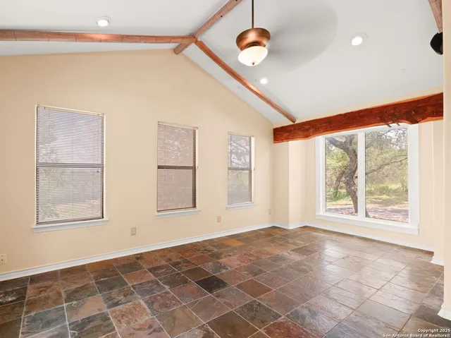 a large white kitchen with stainless steel appliances kitchen island granite countertop a refrigerator and a stove top oven