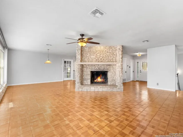 a view of empty room with a fireplace and fan