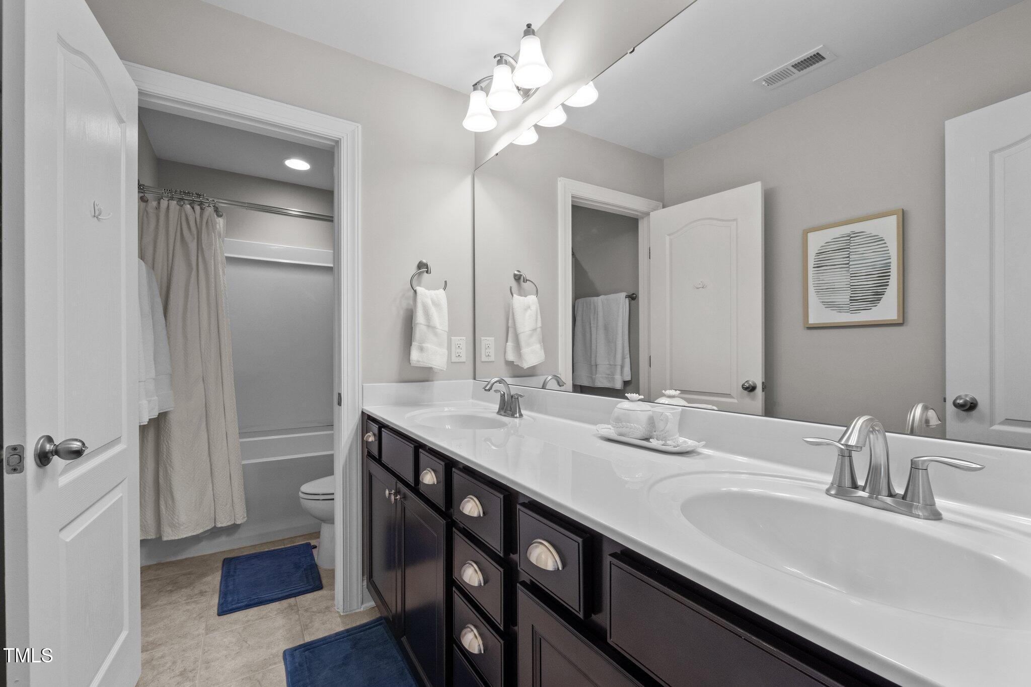 212 Crisp Road Durham, NC 27713 - Photo 25 of 36 a bathroom with a double vanity sink a and a mirror