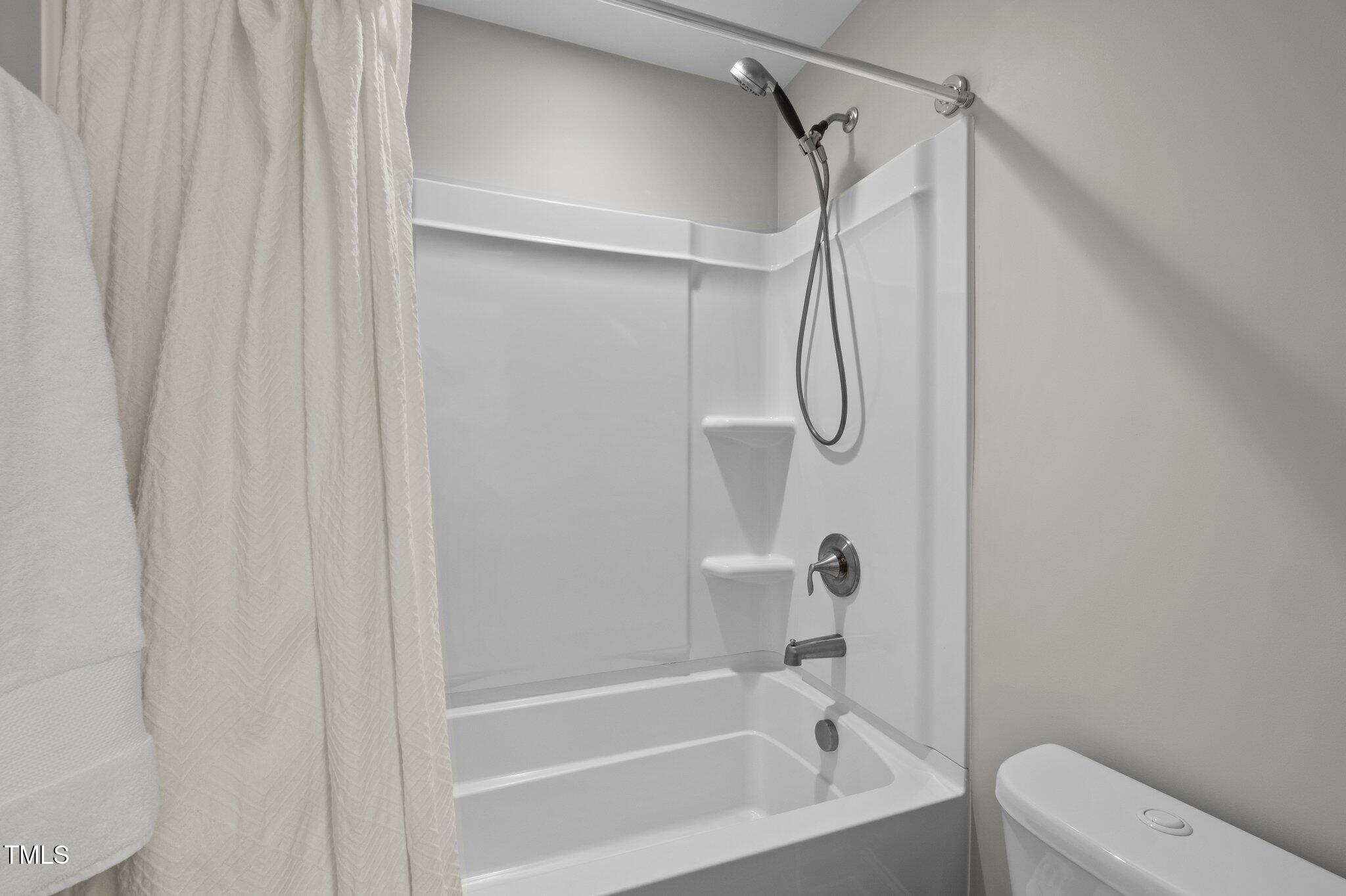 212 Crisp Road Durham, NC 27713 - Photo 26 of 36 a bathroom with a bath tub with a shower curtain