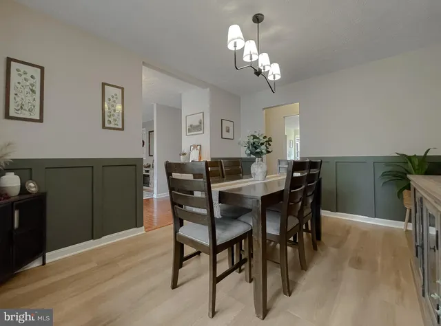 a view of a dining room with furniture a chandelier and a window