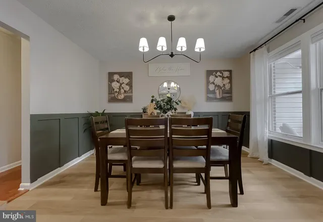 a bedroom with a bed dresser and a chandelier