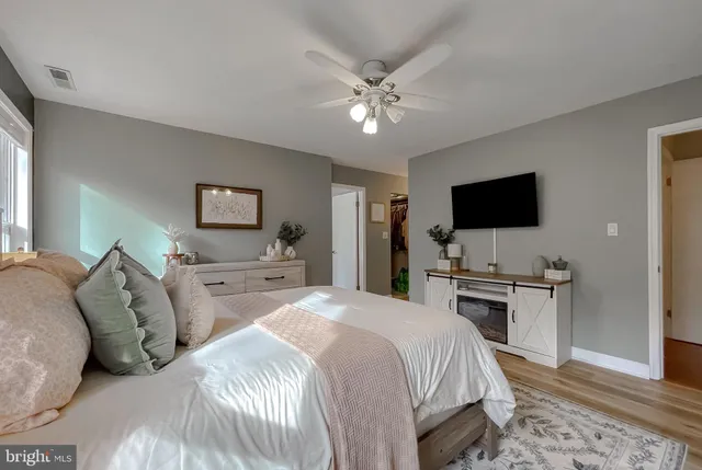 a spacious bathroom with a granite countertop sink a mirror and a bathtub