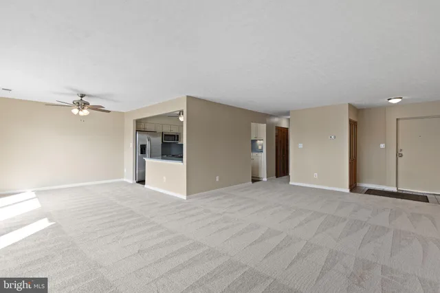 a view of an empty room with a kitchen