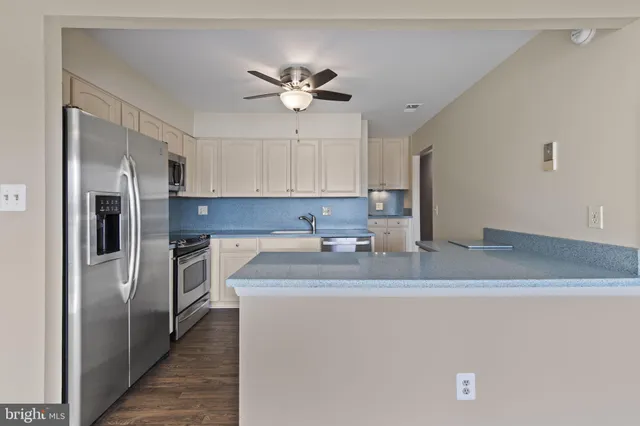 a kitchen with stainless steel appliances granite countertop a sink a refrigerator a washer and dryer