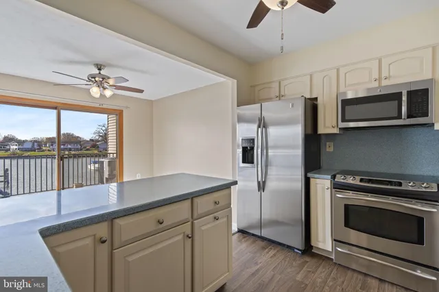 a kitchen with stainless steel appliances a stove a microwave and a view of chandelier