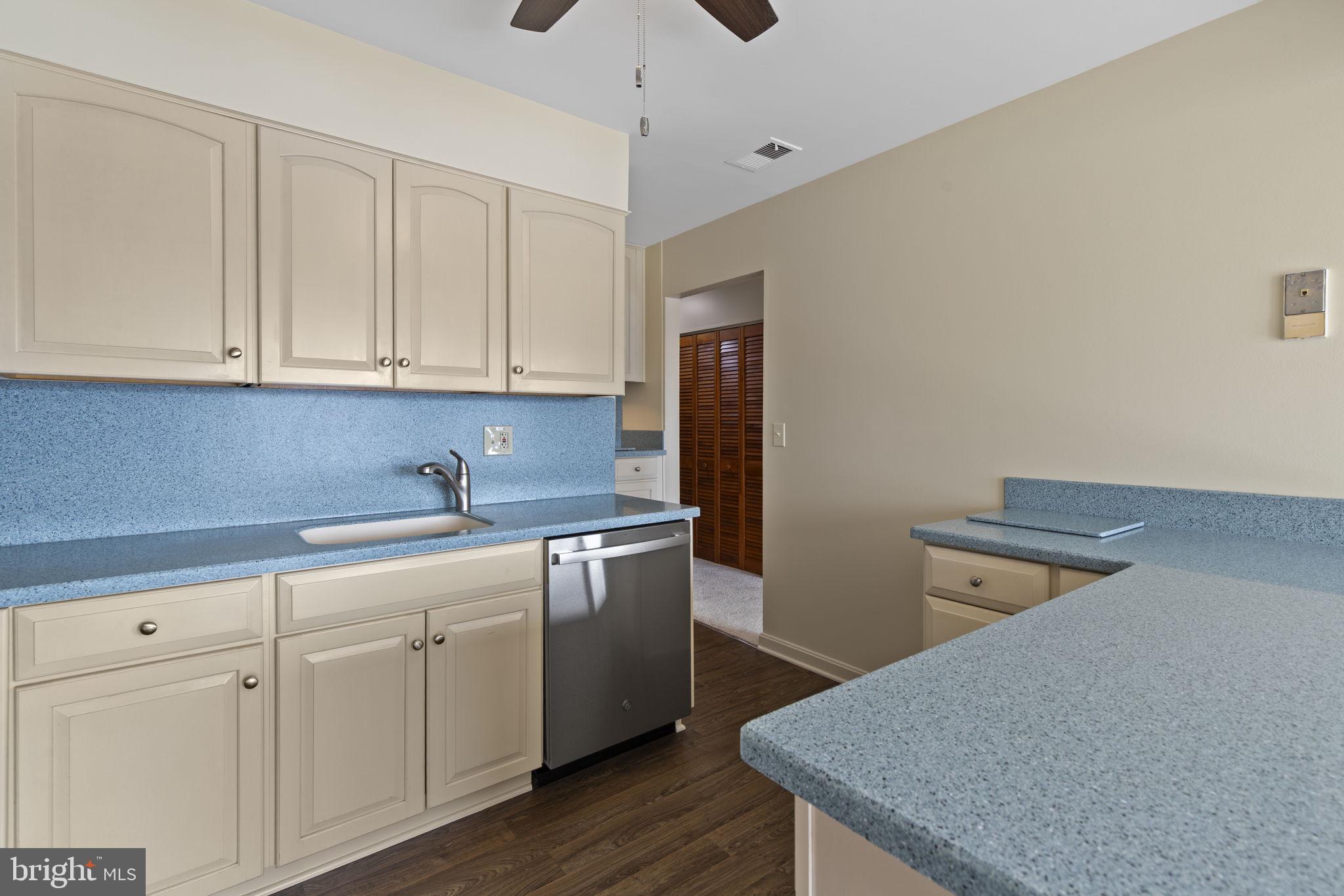 546 Riviera Drive, Unit 546B Joppa, MD 21085 - Photo 9 of 30 a kitchen with stainless steel appliances granite countertop a sink a stove and white cabinets with wooden floor