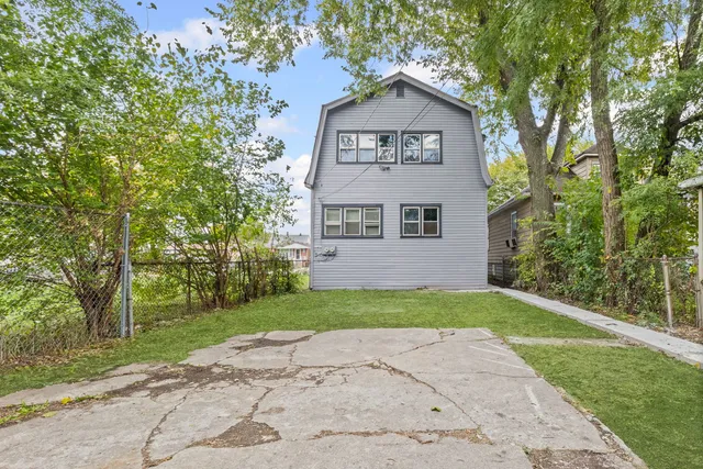 a front view of a house with a yard and trees