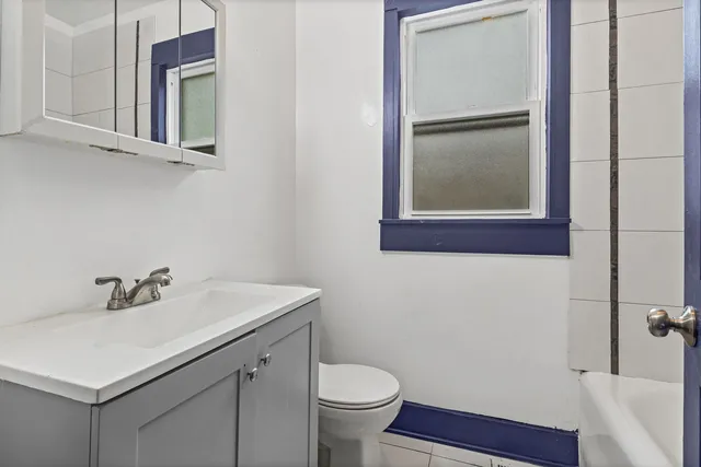 a bathroom with a sink mirror and toilet