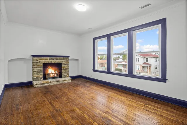 a view of an empty room with a window and fireplace
