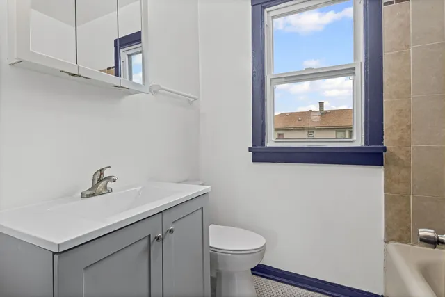 a bathroom with a sink mirror and toilet