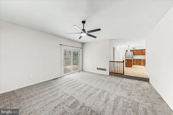 a view of a livingroom with a ceiling fan and window