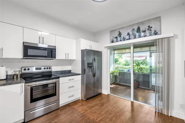 a kitchen with stainless steel appliances a stove a sink and a microwave