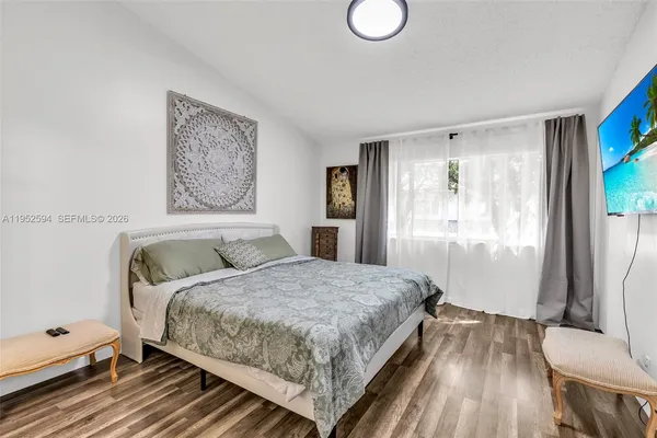 a bedroom with a bed and wooden floor