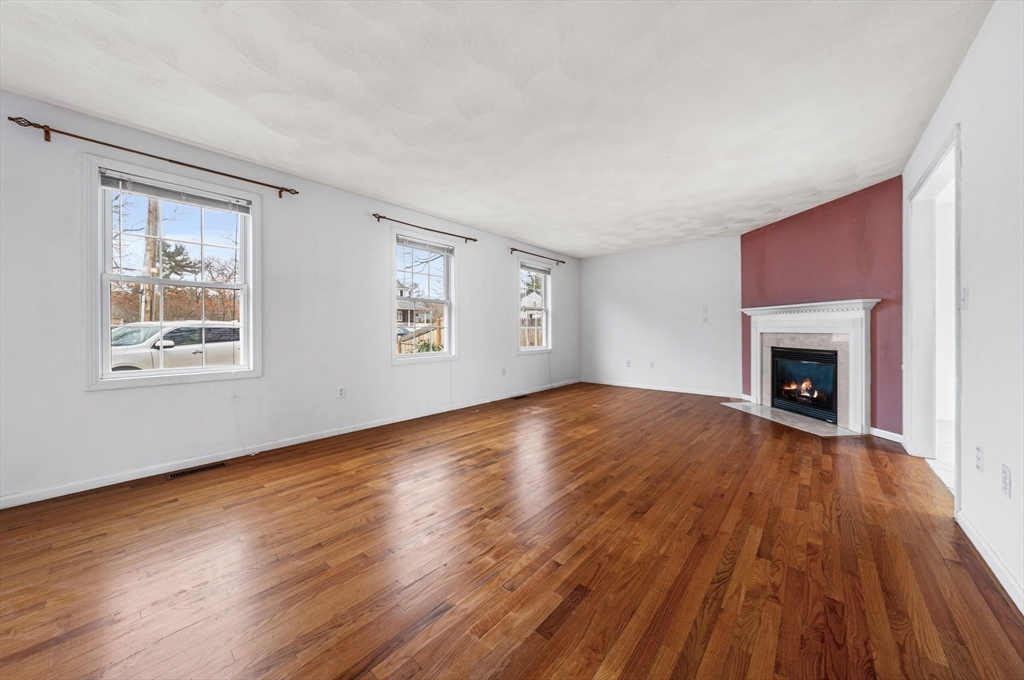 12 Horton Lane Billerica, MA 01821 - Photo 11 of 21 a view of empty room with wooden floor and fireplace