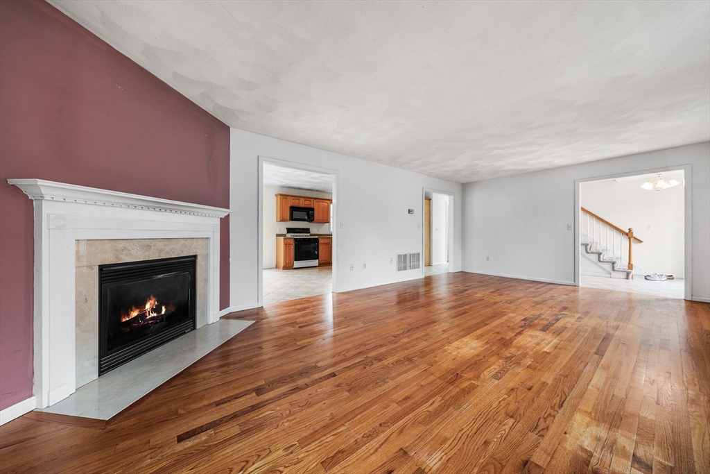 12 Horton Lane Billerica, MA 01821 - Photo 3 of 21 a view of an empty room with wooden floor fireplace and a window