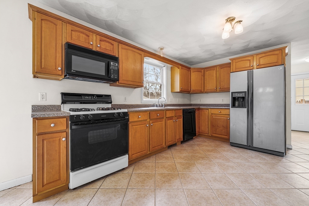 12 Horton Lane Billerica, MA 01821 - Photo 8 of 21 a kitchen with stainless steel appliances granite countertop a stove top oven a refrigerator and a sink