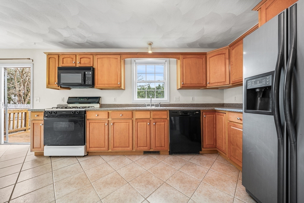 12 Horton Lane Billerica, MA 01821 - Photo 9 of 21 a kitchen with granite countertop a stove top oven sink and cabinets
