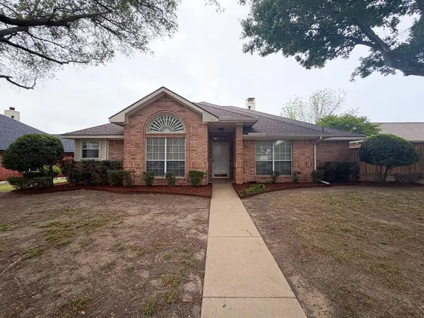 a front view of a house with a yard and trees