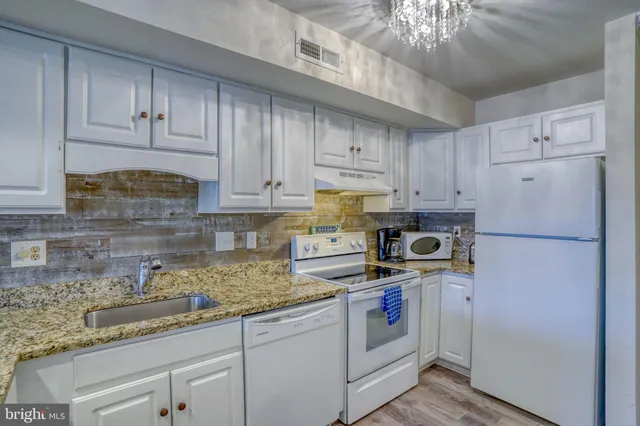 a kitchen with granite countertop cabinets stainless steel appliances a sink and a window