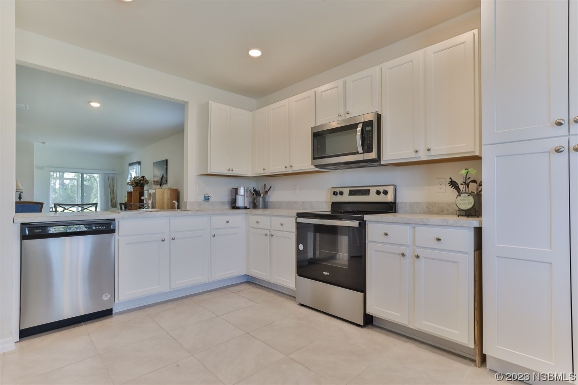 302 Sunset View Drive Edgewater, FL 32141 - Photo 13 of 45 a kitchen with stainless steel appliances granite countertop white cabinets a sink a stove a microwave and a refrigerator
