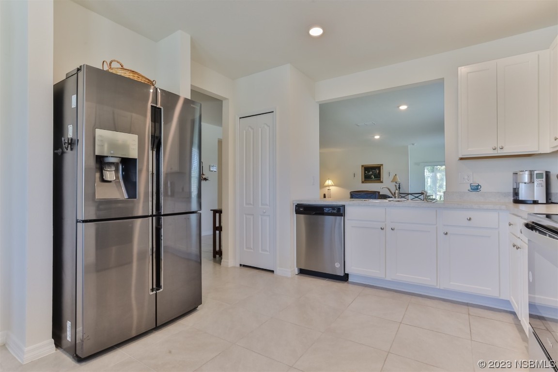 302 Sunset View Drive Edgewater, FL 32141 - Photo 15 of 45 a kitchen with stainless steel appliances a refrigerator sink and cabinets