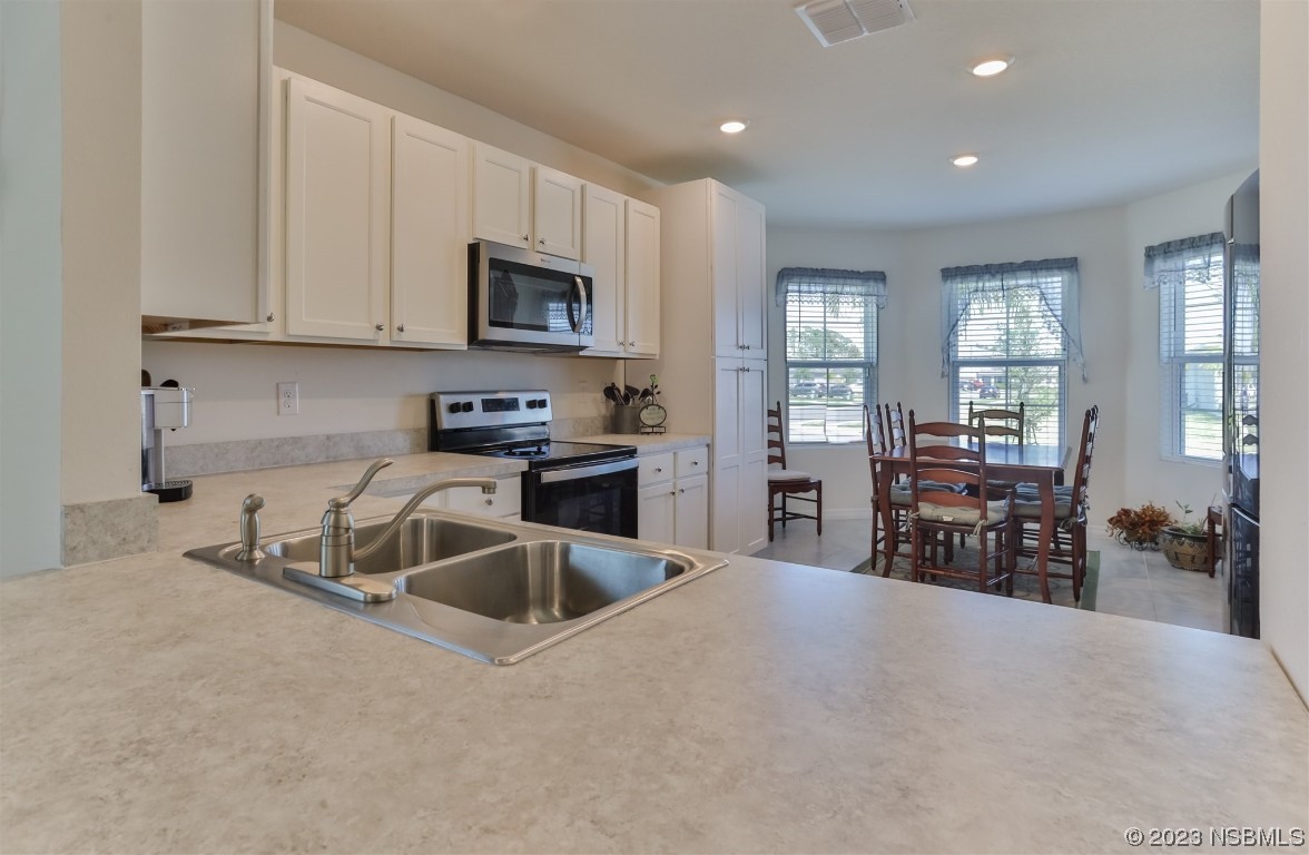 302 Sunset View Drive Edgewater, FL 32141 - Photo 17 of 45 a kitchen with stainless steel appliances kitchen island sink refrigerator and cabinets