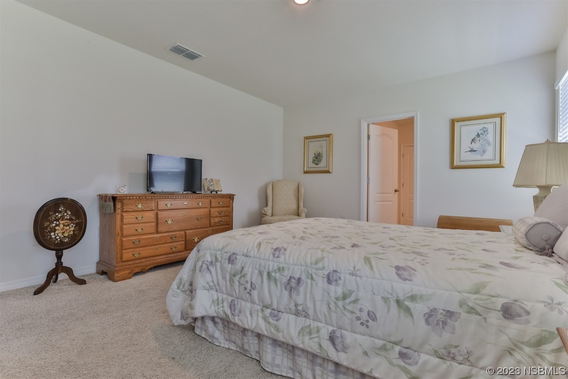 302 Sunset View Drive Edgewater, FL 32141 - Photo 20 of 45 a bedroom with a bed and a chandelier