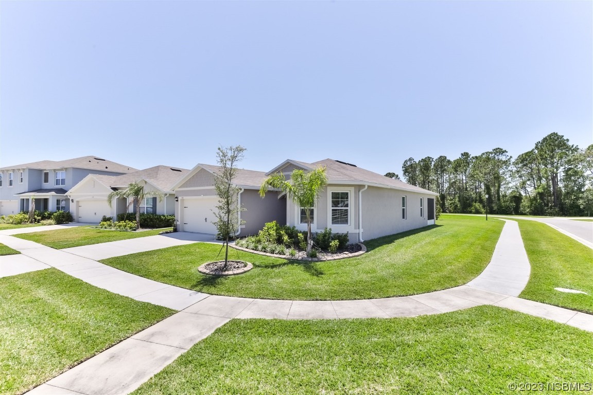 302 Sunset View Drive Edgewater, FL 32141 - Photo 2 of 45 a view of a big house with a big yard and potted plants