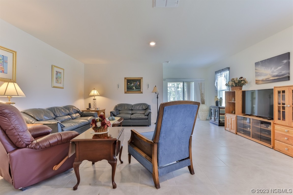 302 Sunset View Drive Edgewater, FL 32141 - Photo 8 of 45 a living room with furniture a flat screen tv and kitchen view