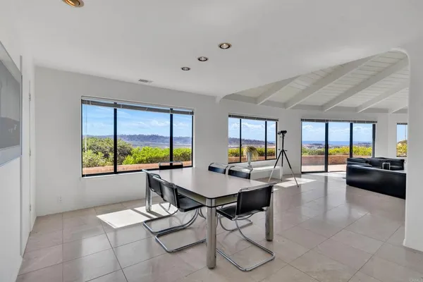 a view of a dining room with furniture large windows and wooden floor