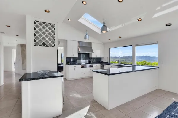 a kitchen with granite countertop a sink a counter top space and stainless steel appliances