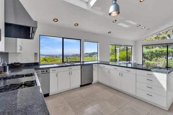 a large white kitchen with a large window
