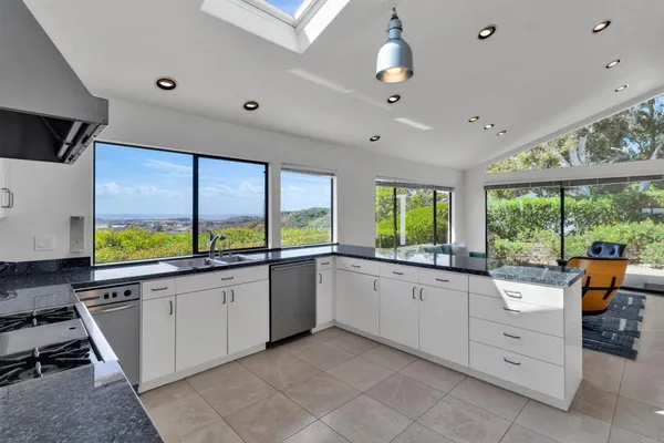 a large white kitchen with a large window