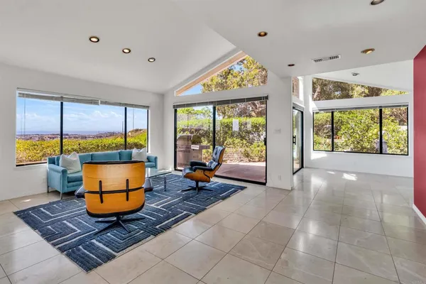 a living room with furniture and a floor to ceiling window