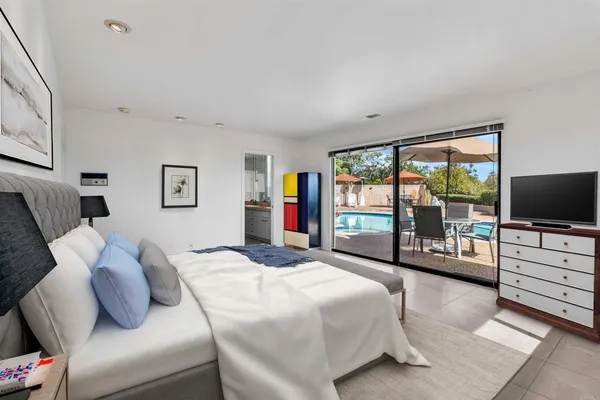 a bedroom with a balcony a bed and a flat screen tv