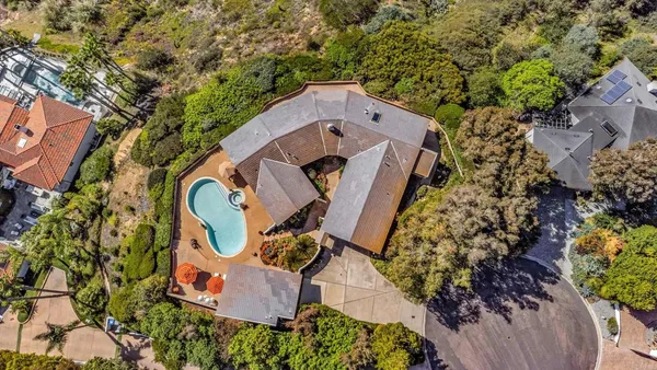 an aerial view of a residential house with an outdoor space and seating