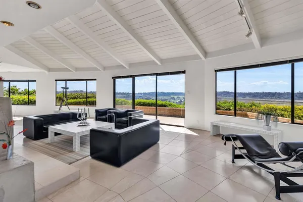 a living room with furniture tv and large windows